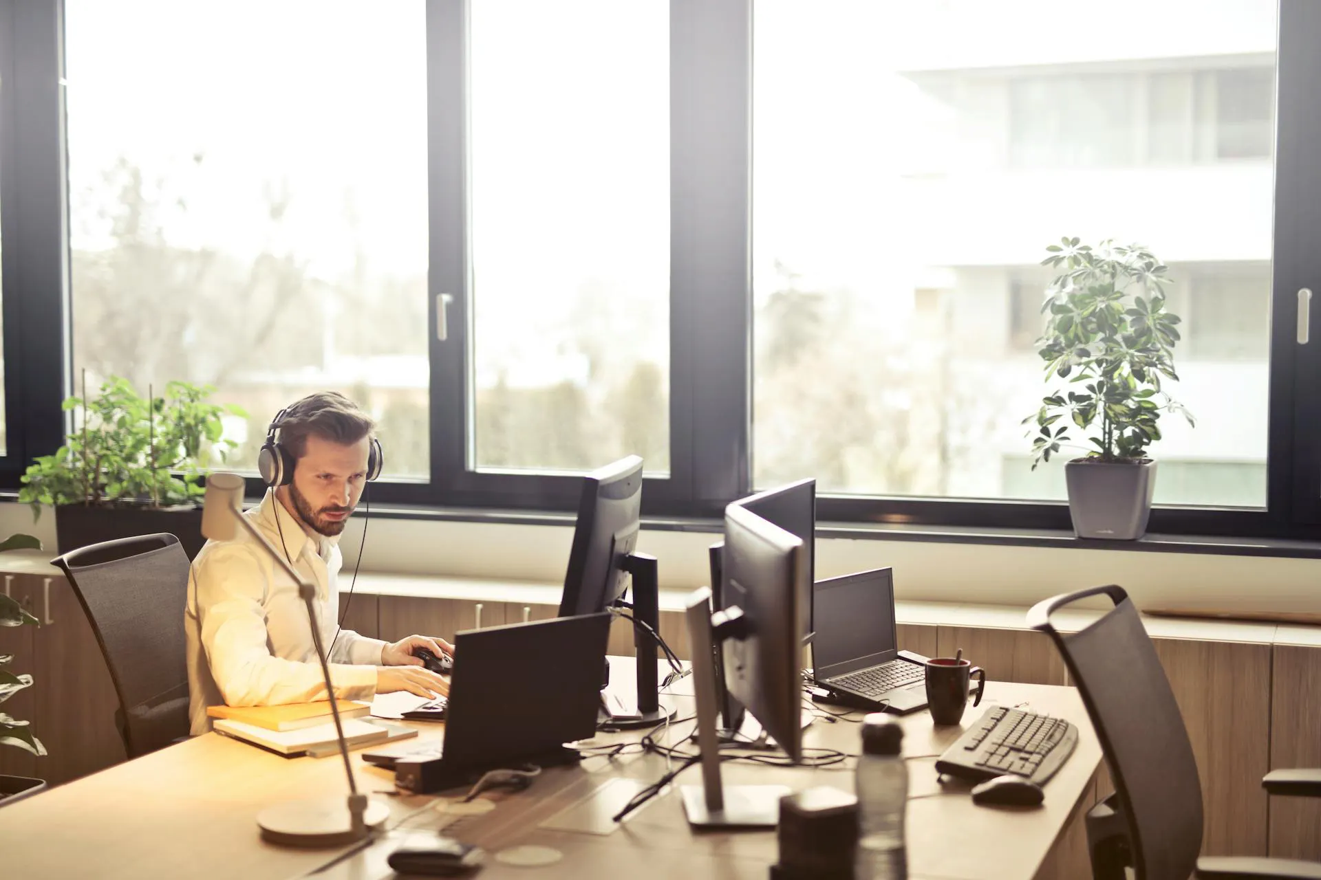 Man working at a desk with multiple monitors.