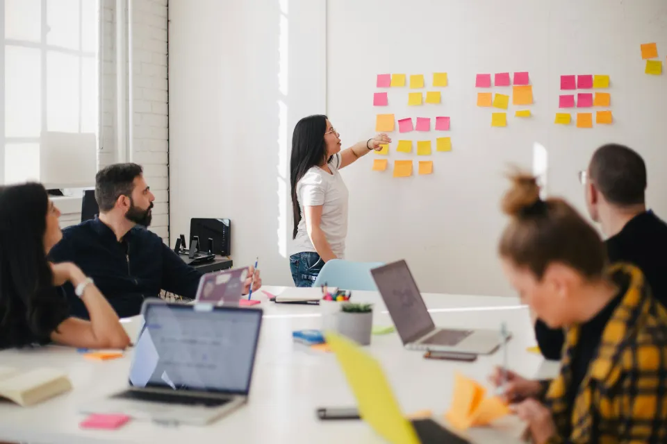 Team brainstorming ideas using sticky notes on a board