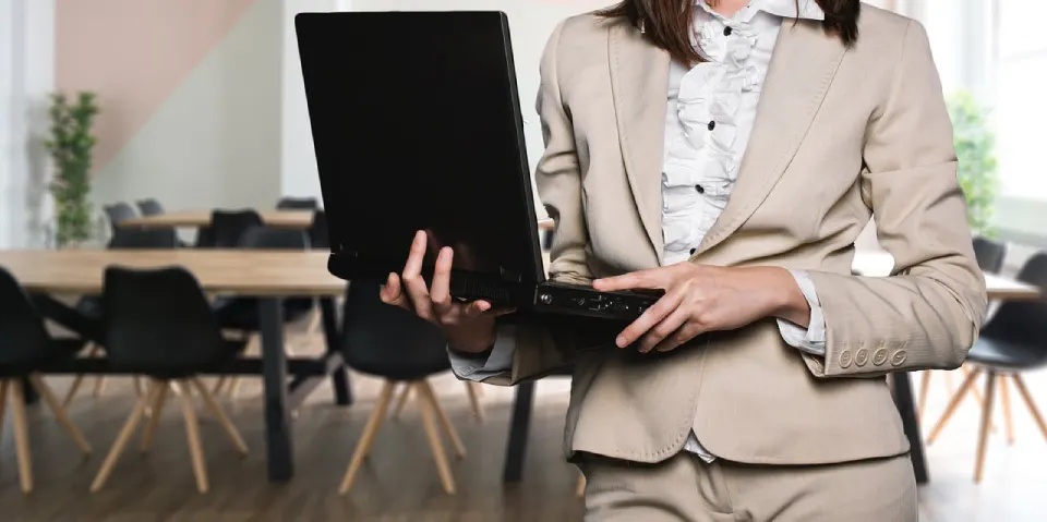 Businesswoman holding a laptop in a conference room