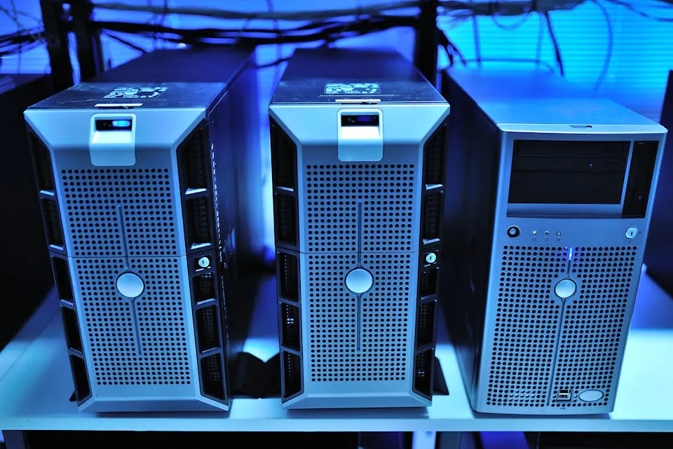 Three computer servers in a blue-lit server room