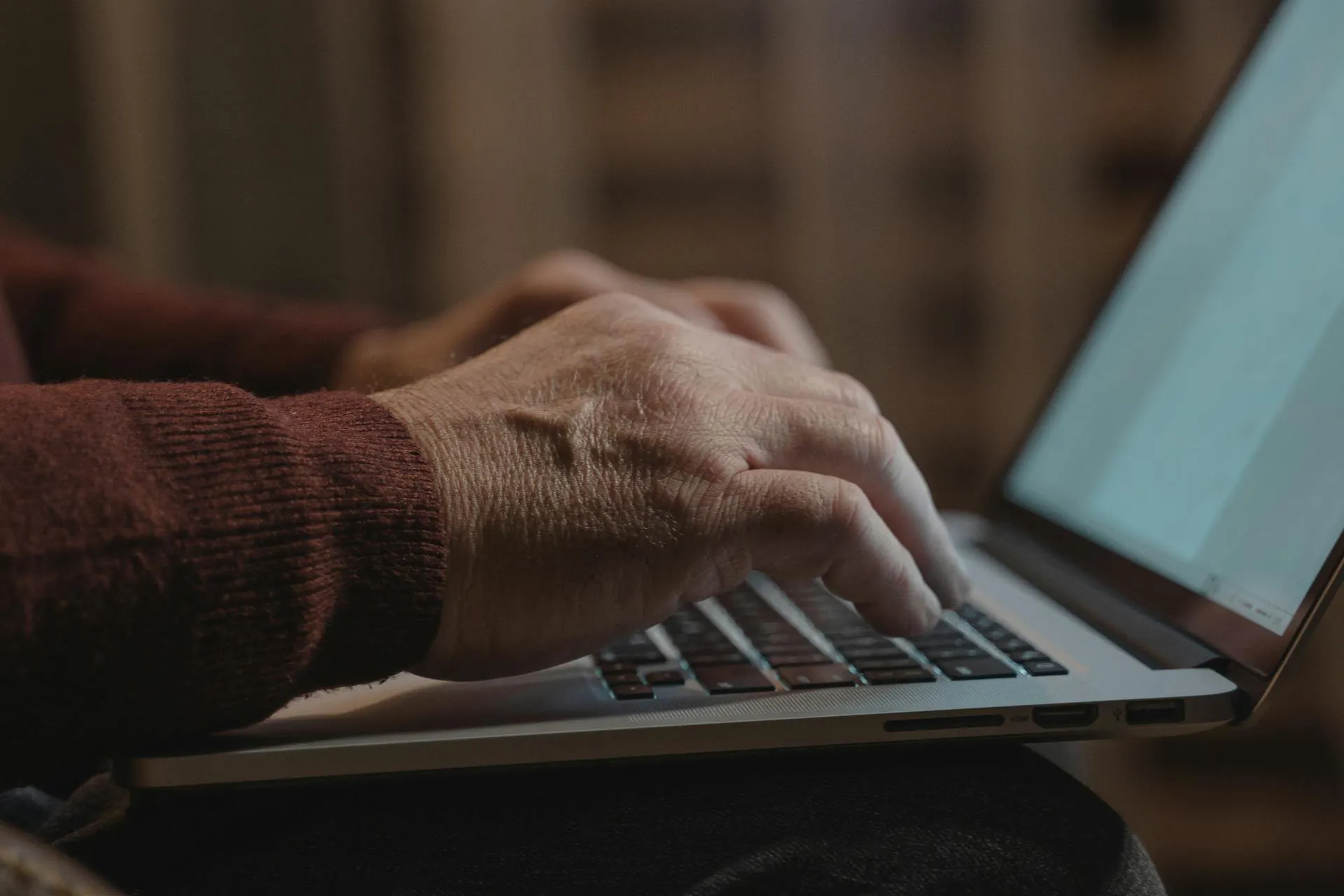 Hands typing on a laptop keyboard.